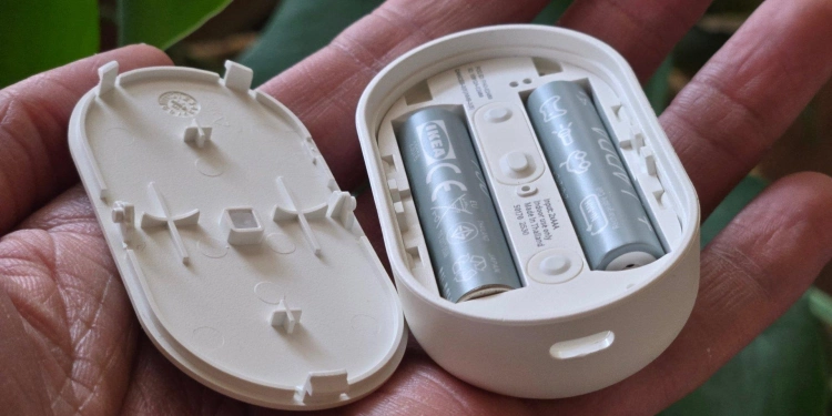 Aaa batteries inside of an open ikea bilresa smart remote with dual buttons
