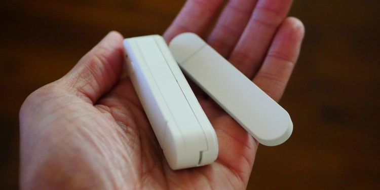 Hand holding an ikea myggbett door and window sensor