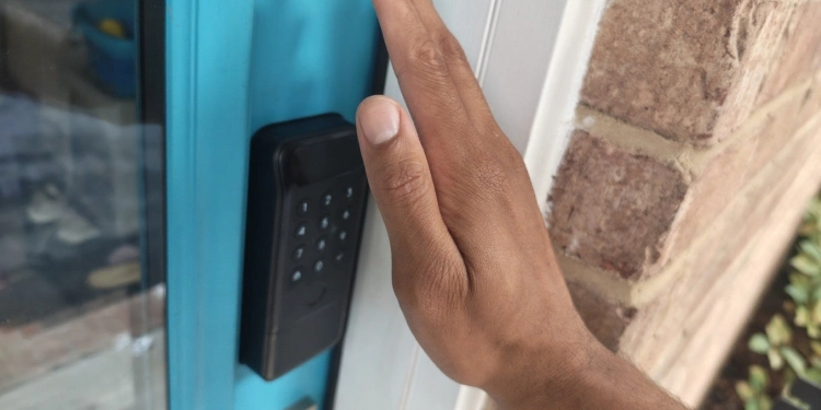 Hand placed in front of a SwitchBot Lock Vision Pro.