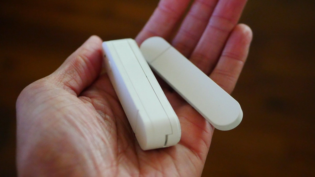 Hand holding an ikea myggbett door and window sensor