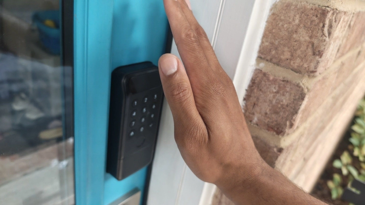 Hand placed in front of a SwitchBot Lock Vision Pro.