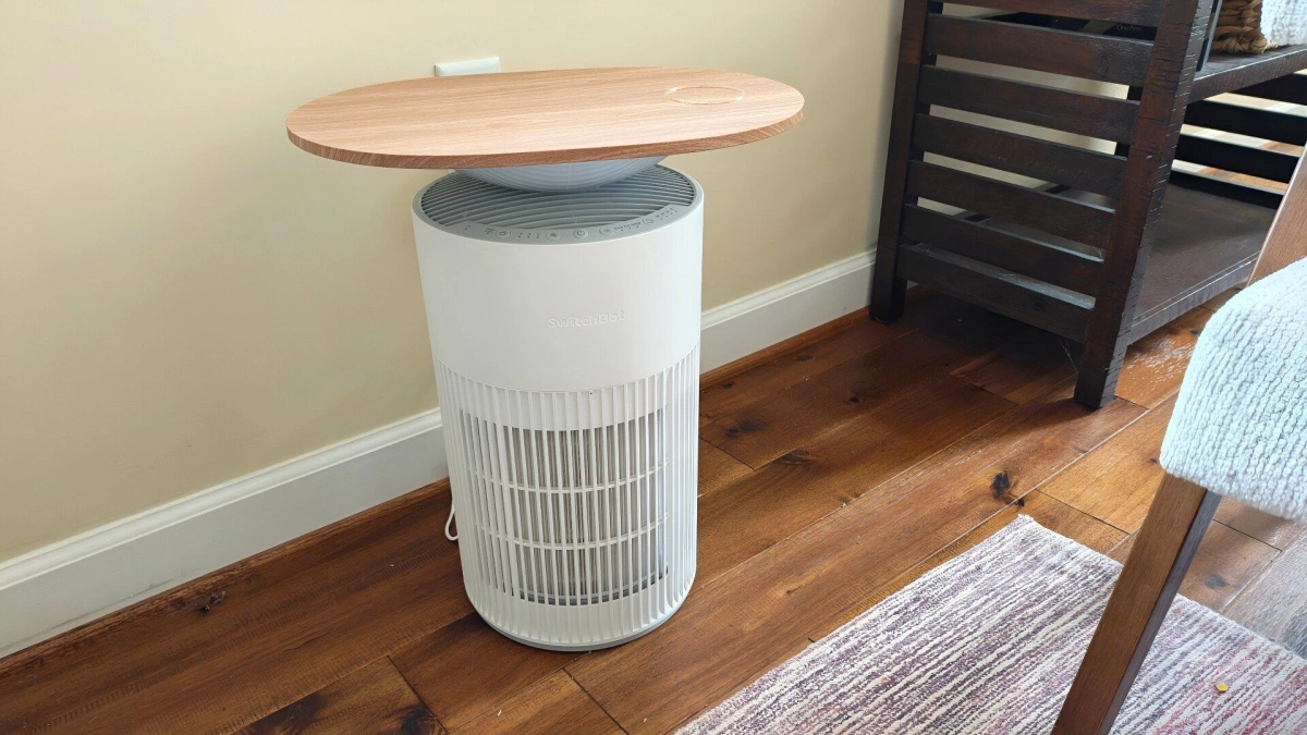 Switchbot air purifier table next to a rug and bookshelf