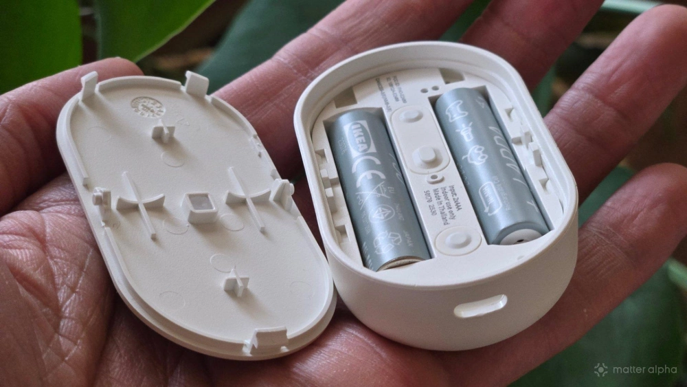 Aaa batteries inside of an open ikea bilresa smart remote with dual buttons