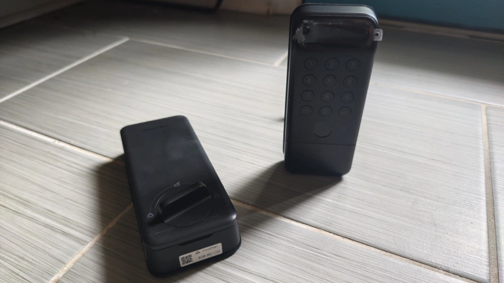 Two parts of the SwitchBot Lock Vision Pro on a floor. Two parts of the SwitchBot Lock Vision Pro on a floor.