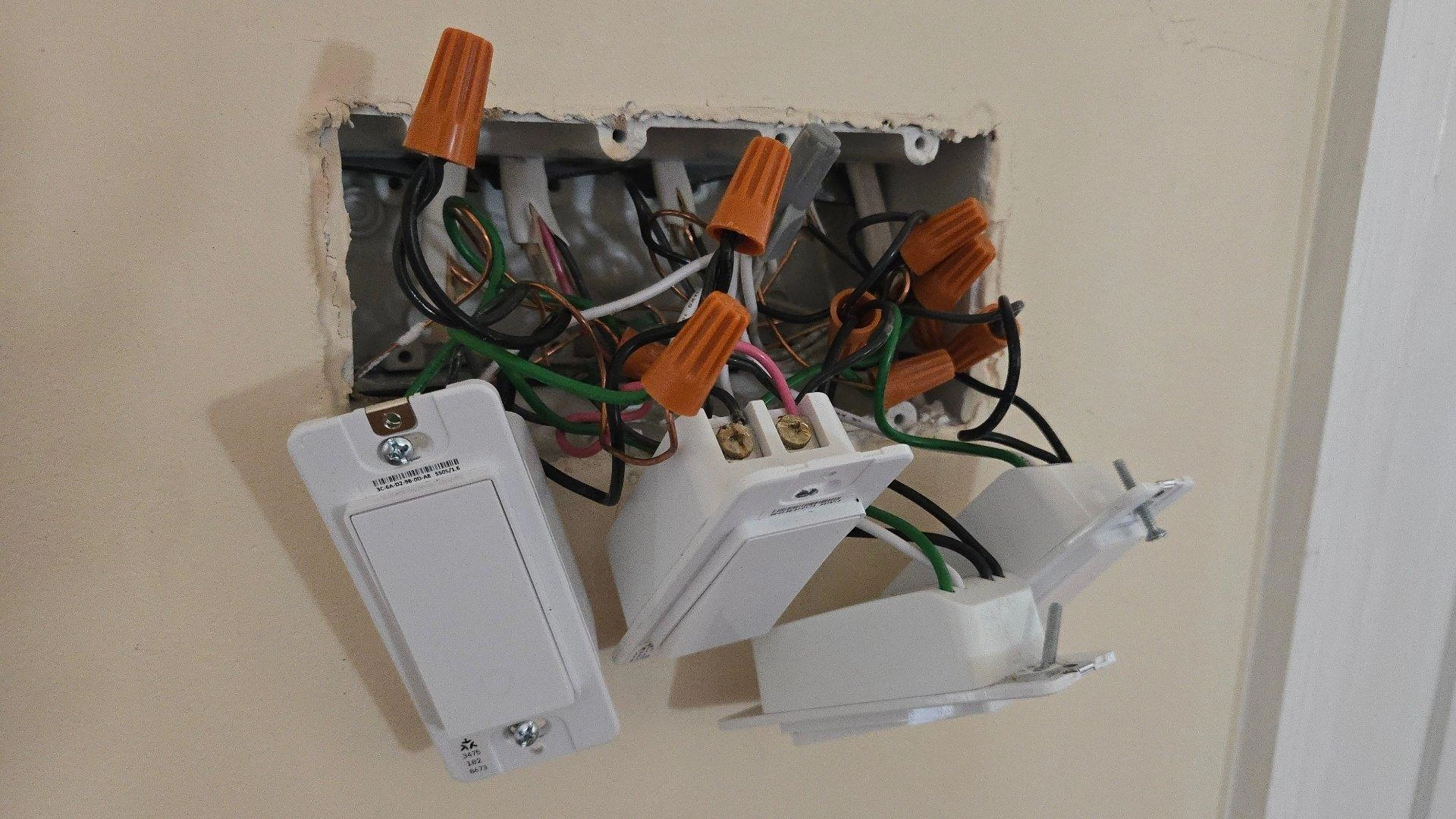 Four tapo smart switches hanging out of a wall