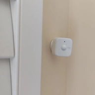 SwitchBot presence sensor next to a window shutter.