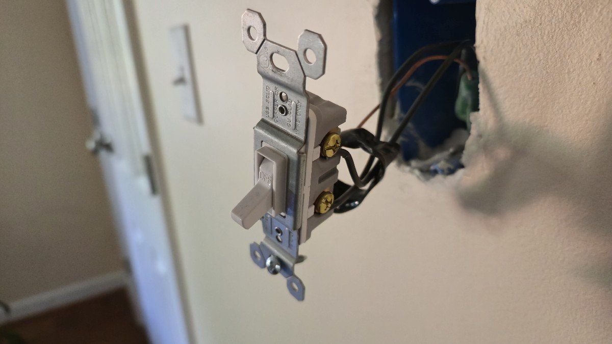 A light switch hanging from a wall